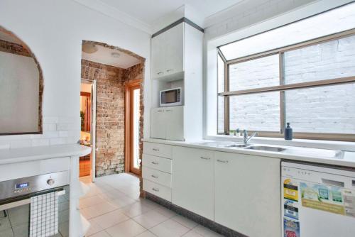 悉尼3 Bedrooms - Darling Harbour - Darghan Street 2 E-Bikes Included的白色的厨房设有水槽和窗户