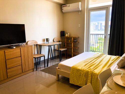 麦克坦BH Mangrove Condos的酒店客房设有床、电视和桌子。