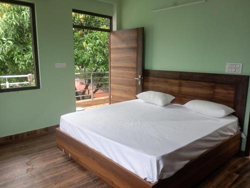 瑞诗凯诗Crescent Moon Homestay的一间卧室配有一张带白色床单的床和两个窗户。