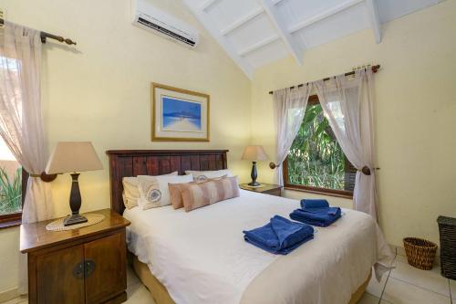 绍斯布鲁姆San Lameer Villa 2909的一间卧室配有一张带2条蓝色毛巾的床