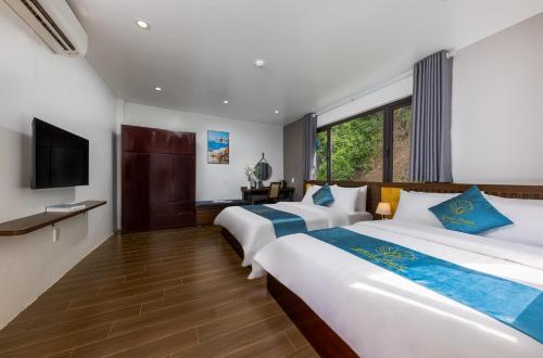吉婆岛CatBa Green Pearl Hotel的酒店客房设有两张床和电视。