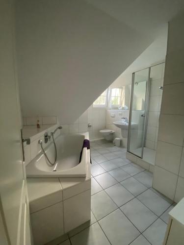 朗克维茨Am Jungfernberg 2的白色的浴室设有浴缸和水槽。