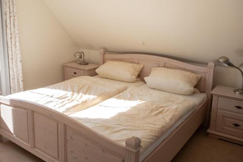 朗克维茨Am Jungfernberg 2的卧室配有白色的床和2个枕头