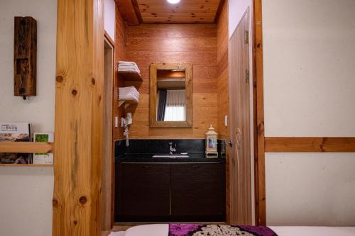 全州市Jeonju Wangyijimil Hanok Hotel的一间带水槽和镜子的浴室