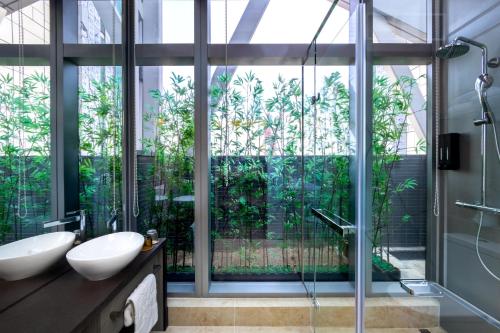 香港Starphire Hotel的一间带两个水槽和玻璃淋浴间的浴室
