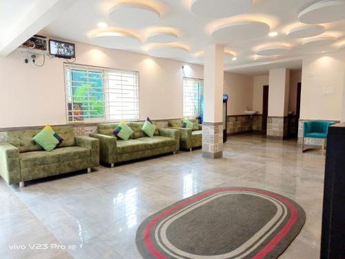 卡基纳达De Crown Luxury Hotel的客厅配有沙发,地板上铺有地毯。