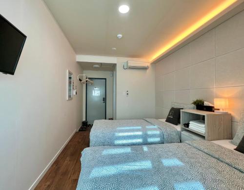 首尔梨大 首爾大旅館的一间带两张床和一张沙发的卧室
