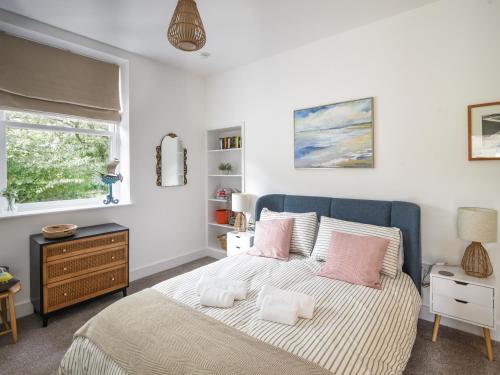 莱姆里吉斯Seaward的一间卧室配有带粉红色枕头的床和窗户。