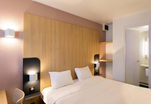 拉内斯泰尔B&B HOTEL Lorient Lanester的卧室配有一张带两个枕头的大白色床