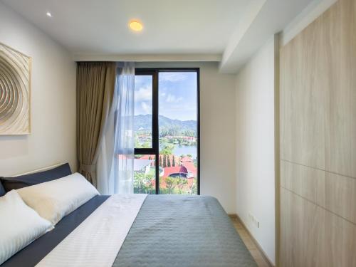 邦涛海滩Skypark Laguna apartments Bangtao的一间卧室设有一张床和一个大窗户