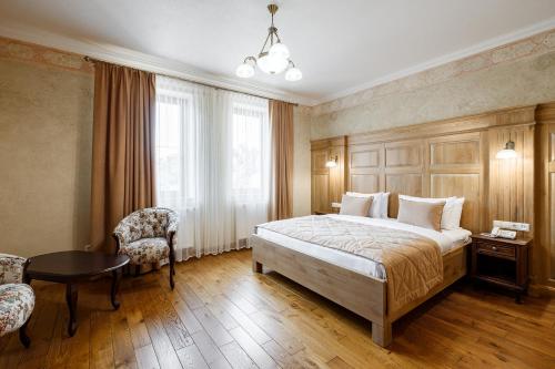 伊万诺-弗兰科夫斯克GANZ HOTEL的卧室配有1张床、1张桌子和1把椅子