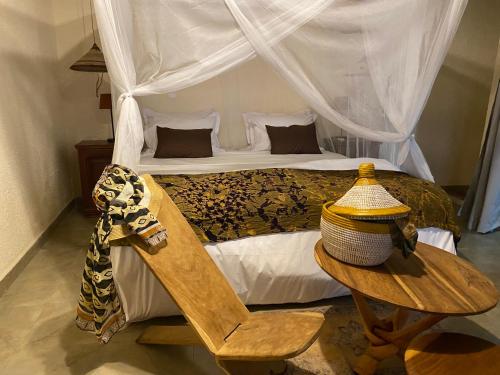ToubakoutaToubacouta Lodges的一间卧室配有一张床和一张桌子及椅子