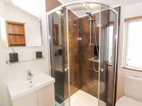 科克茅斯No 7 Skiddaw View的浴室里设有玻璃门淋浴