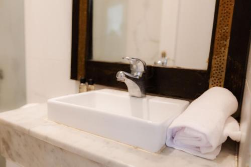 卡萨布兰卡WINDSOR HOTEL CITY CENTER的浴室水槽,在镜子旁配有毛巾