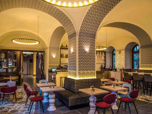 维也纳维也纳美居第一酒店的一间带桌椅的餐厅和一间酒吧