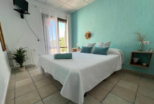 哈维亚La Puerta Azul的一间卧室配有一张蓝色墙壁的床和一扇窗户