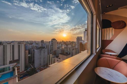 圣保罗Canopy By Hilton Sao Paulo Jardins的阳台享有日落的城市美景