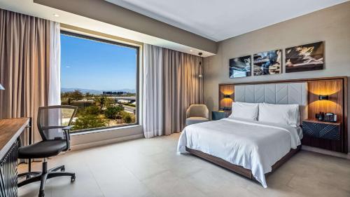 新巴利亚塔Hampton Inn By Hilton Nuevo Vallarta的一间卧室设有一张床和一个大窗户
