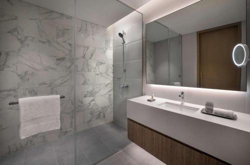 阿布扎比Doubletree By Hilton Abu Dhabi Yas Island Residences的一间带水槽和镜子的浴室