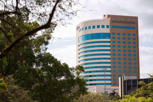 阿雷格里港Hilton Porto Alegre, Brazil的一座高大的建筑,有蓝色的窗户,位于城市