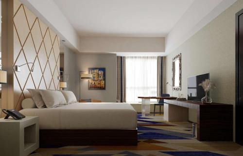 安曼Hilton Amman的一间卧室配有一张大床和一张书桌