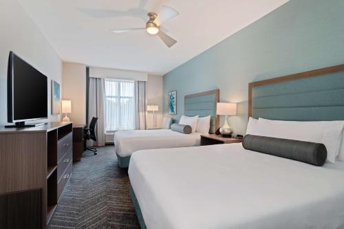 巴拿马城海滩Homewood Suites By Hilton Panama City Beach, Fl的酒店客房设有两张床和一台平面电视。