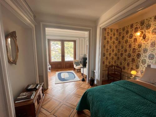 纳沙泰尔Le Faubourg 29的一间卧室配有一张带绿色棉被的床和窗户。