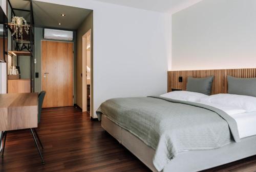 施韦夏特HEINhotel vienna airport的一间卧室配有一张大床和一张桌子