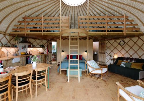 GodshillTree Field Yurt at Moor Farm的蒙古包内带高架床的客房