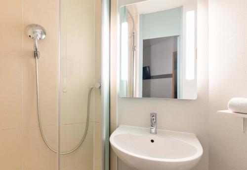 圣博内德米尔B&B HOTEL Lyon Saint-Bonnet Mi-Plaine的浴室配有盥洗盆和带镜子的淋浴