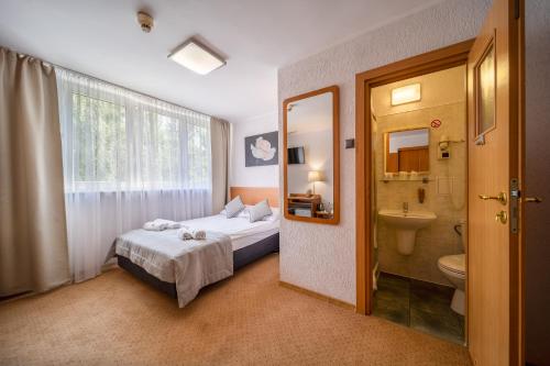 波兹南波兹南格罗马达酒店的一间卧室配有床、水槽和卫生间