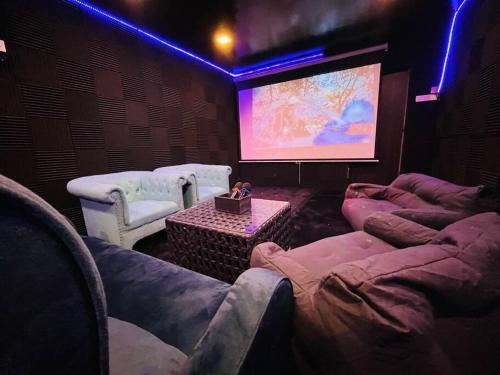 乔治市Luxe Bean Bag Cinema的电影室配有沙发和大屏幕