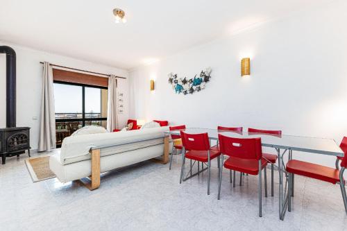 拉戈斯Lagos Sea View by Algarve Golden Properties的一间带床和红色椅子的用餐室