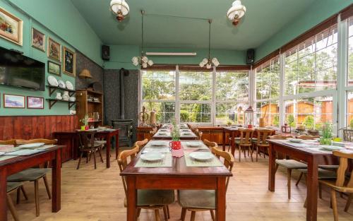 新伊钦斯卡尔卡奇酒店的餐厅设有木桌、椅子和窗户。