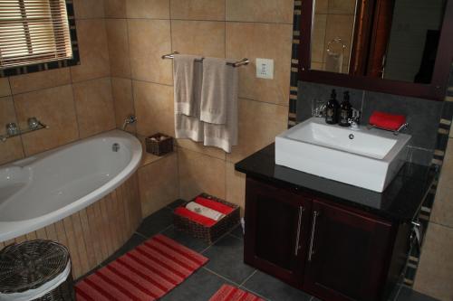 白河White River Country Estate Self Catering Apartment的带浴缸、水槽和浴缸的浴室