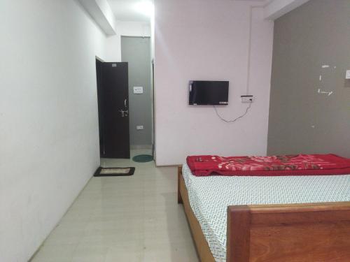 因帕尔OYO HOTEL RASU的客房设有两张床和一台墙上的电视。