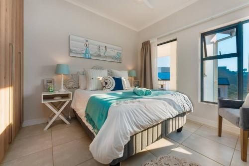 巴利托864 Ballito Hillis Luxury Estate Family Apartment的一间卧室配有一张床、一张桌子和一个窗户。