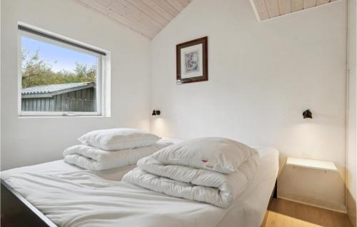 斯楚厄3 Bedroom Cozy Home In Struer的窗户间内的床上的2个枕头