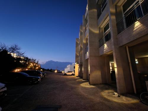 仁川市Hotel Hue Loft的街道上,晚上有汽车停在建筑物旁边