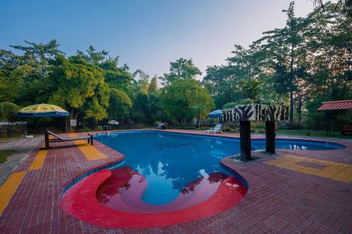 坎哈Jungle King Resort的红色白色和蓝色的游泳池