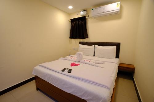 钦奈Bava Inn的一间卧室配有一张铺有白色床单和鲜花的床。