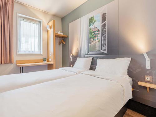 奥斯特瓦尔德B&B HOTEL Strasbourg Sud Ostwald的一张大白色的床,位于酒店客房内