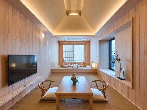 奈良新若狭酒店的配有桌椅和电视的客房