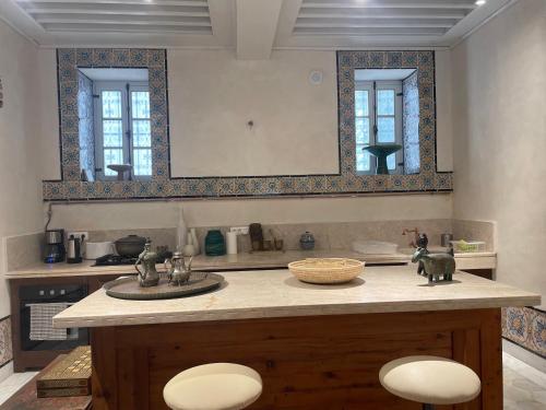 突尼斯Maison typique de la médina的厨房配有带两个水槽和两个镜子的台面