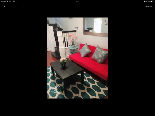 巴尔的摩Gateway en-suite bedroom next jhu的客厅里一张红色的沙发,配有桌子