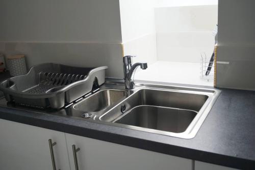 基里缪尔Self-contained 1-Bed Apartment in Kirriemuir的厨房水槽旁设有碗碟干燥架