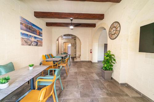 艾因西莱姆49 Sunrise Lodge的餐厅设有桌椅和墙上的时钟