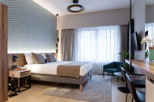 卢森堡The Central Kirchberg - Smart ApartHotel的配有一张床和一张书桌的酒店客房