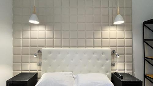 戛纳乐弗洛里安酒店的一间卧室配有白色床和2个床头柜