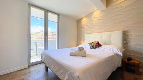 戛纳乐弗洛里安酒店的卧室配有白色的床和大窗户
